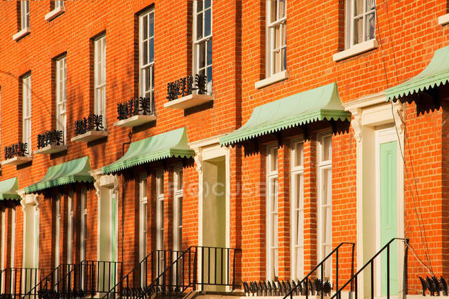 Orangefarbene Häuseraußenwände mit Fenstern und Haustüren in der Stadt, vereinigtes Königreich — Stockfoto