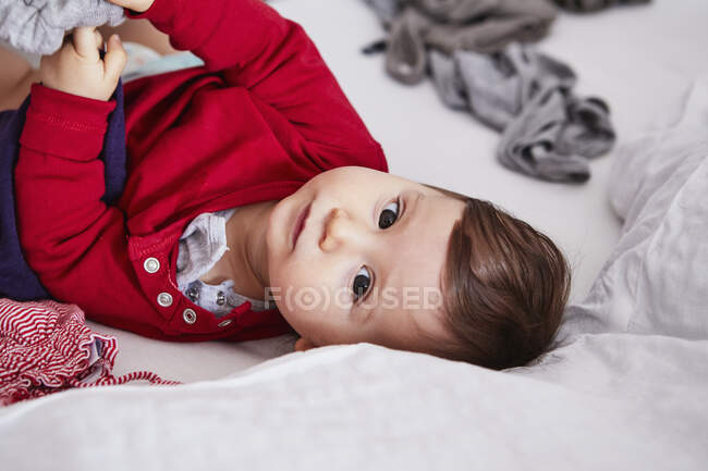 Porträt eines kleinen Mädchens, das auf dem Bett liegt — Stockfoto