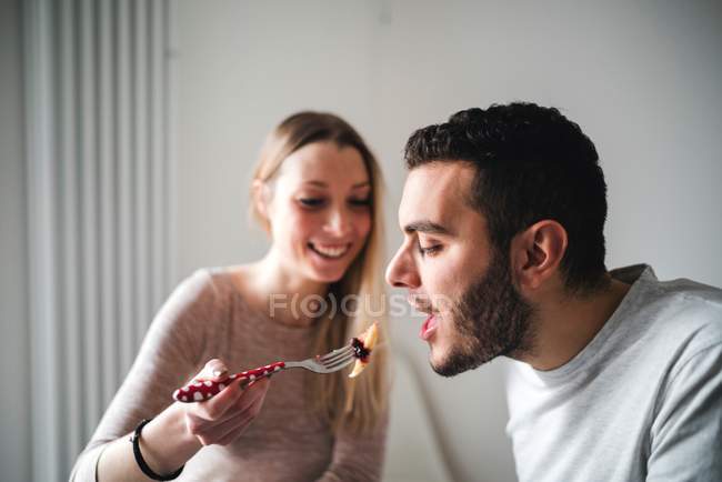 Jovem casal comer panqueca no café da manhã — Fotografia de Stock