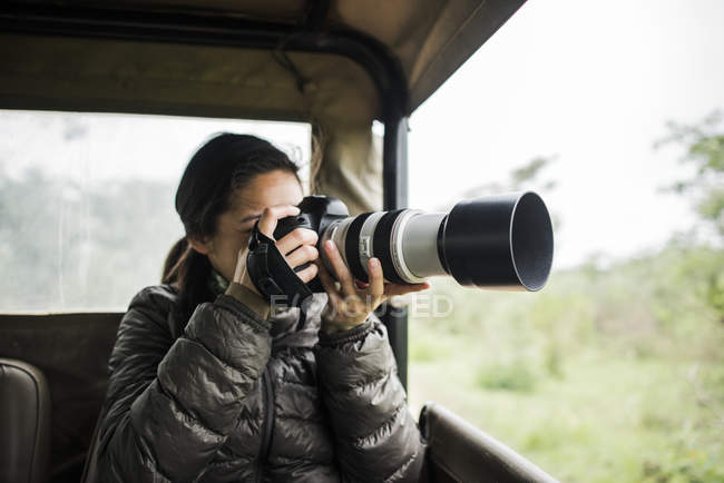Молодая женщина, фотографирующая из туристического грузовика, Национальный парк Крюгер, ЮАР — стоковое фото