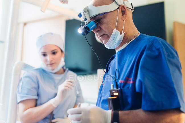 Dentista con lupas binoculares dentales - foto de stock