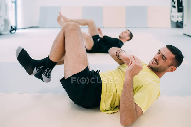 Homem fazendo sentar-se ups no ginásio — Fotografia de Stock