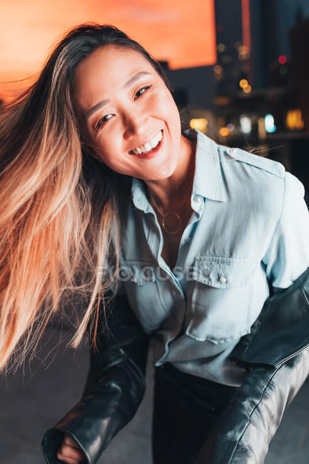Portrait of smiling woman outdoors at sunset — Stock Photo