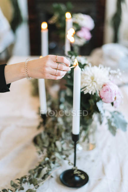 Vista ritagliata della donna che accende le candele — Foto stock