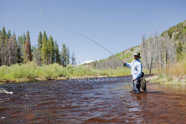 Mann mit Hut Fliegenfischen im Fluss, colorado, Vereinigte Staaten — Stockfoto