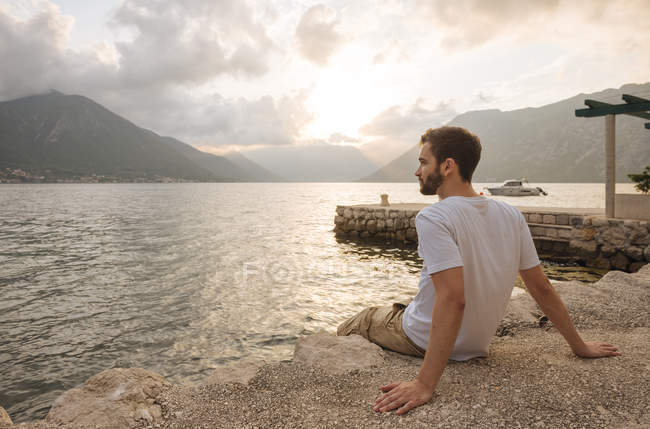 Giovane seduto vicino all'acqua a Kotor, Montenegro, Europa — Foto stock