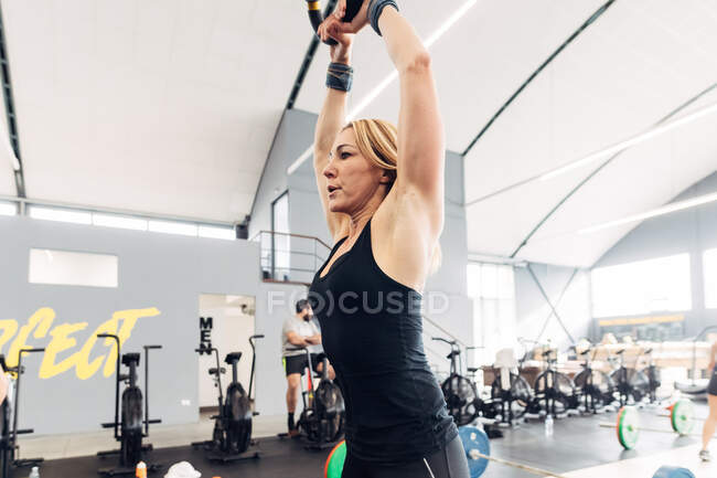 Levantamiento de pesas mujer con campana hervidor en el gimnasio - foto de stock