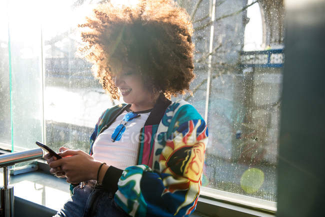 Низький кут зору молода дівчина на відкритому повітрі використанням смартфону, Лондон, Великобританія — Stock Photo