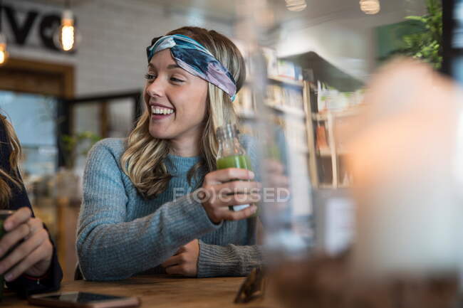 Amigas, sentadas no café, a pôr a conversa em dia, a beber smoothies — Fotografia de Stock