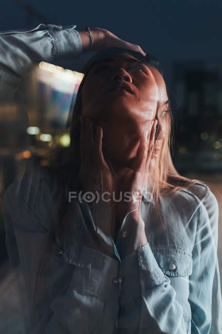 Dupla exposição de mulher adulta média ao ar livre à noite — Fotografia de Stock