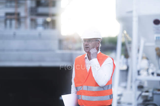 Далеких зору дорослого працівник будівництва, одягнені в помаранчевому жилеті захисні — стокове фото
