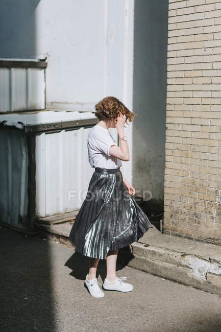 Woman in street twirling in metallic skirt — Stock Photo