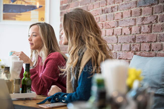 Amigos sentados en la cafetería, tomando café - foto de stock