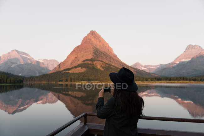 Donna che scatta foto vicino al lago Swiftcurrent, Parco Nazionale del Ghiacciaio, Montana, Stati Uniti — Foto stock