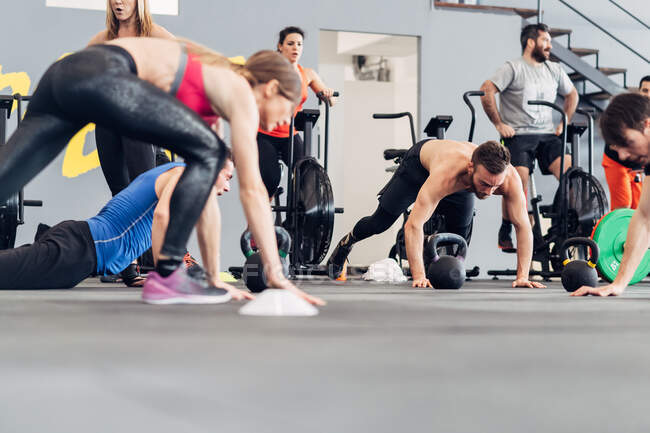 Mittlere Gruppe von Menschen, die im Fitnessstudio trainieren — Stockfoto