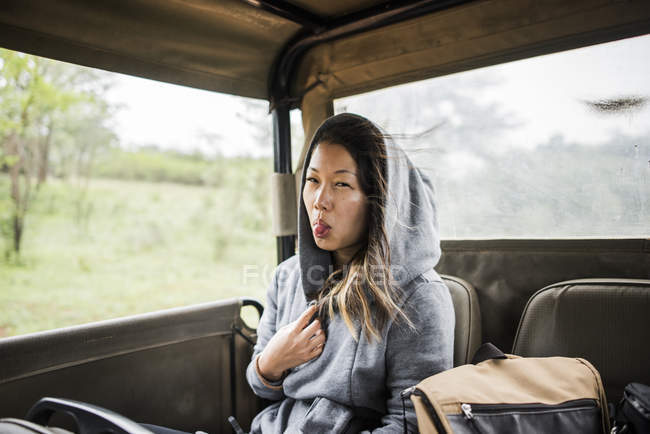 Joven turista mostrando lengua en camión de turismo, Parque Nacional Kruger, Sudáfrica - foto de stock