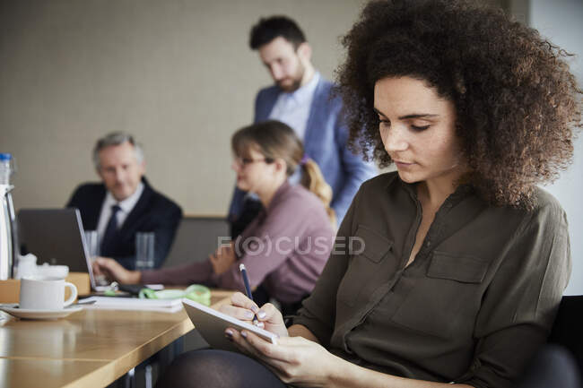 Geschäftsfrau im Büro schreibt auf Notizblock — Stockfoto