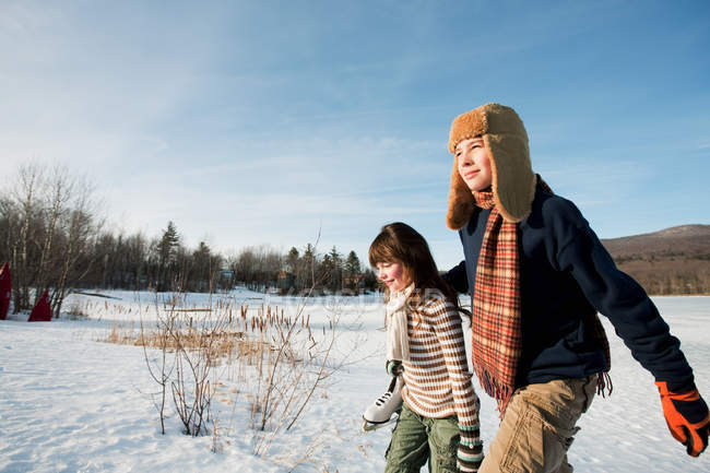 Irmão e irmã caminhando em terra nevada — Fotografia de Stock
