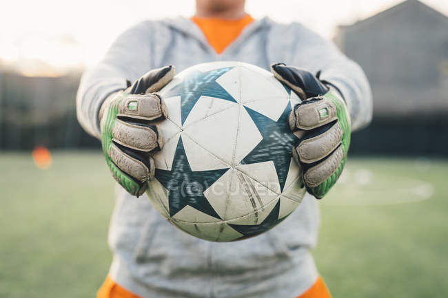 Ausgeschnittenes Bild eines Torhüters mit Handschuhen, der Ball hält — Stockfoto
