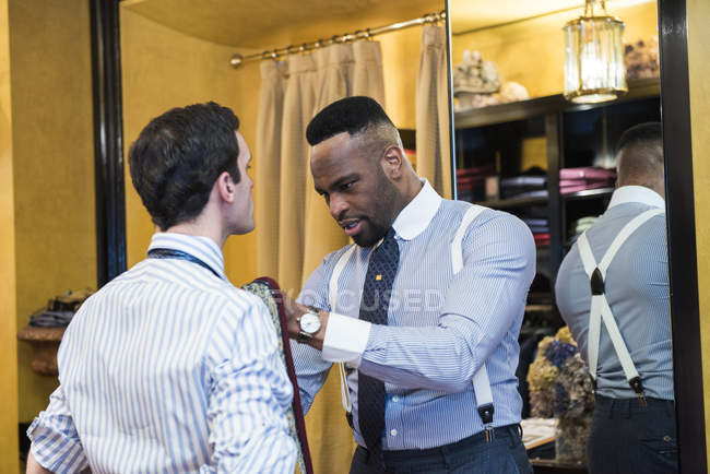 Tailor fastening customer tie in tailors shop — Stock Photo