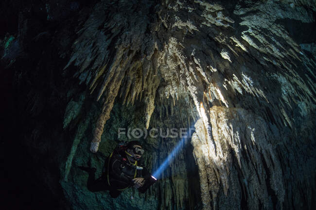 Immersioni subacquee maschili nel fiume sotterraneo (cenote) con formazioni rocciose di stalattiti, Tulum, Quintana Roo, Messico — Foto stock