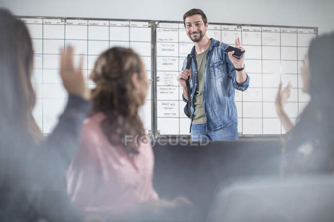 Young man greeting colleagues in office — Stock Photo