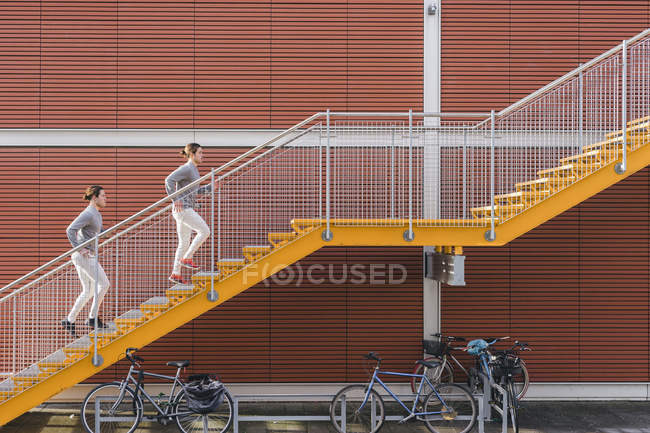Young male twins running up on city stairs — Stock Photo