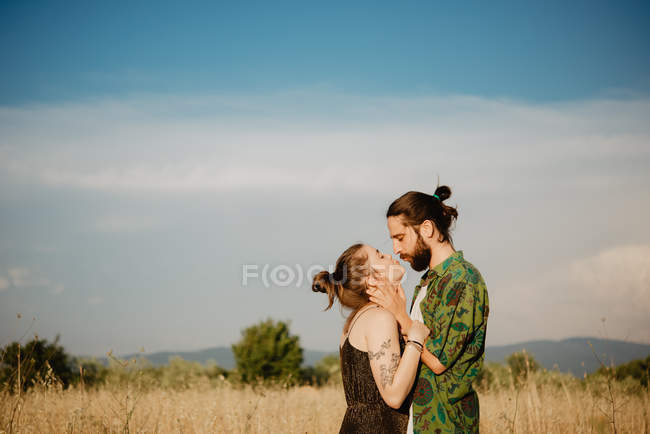 Junges paar auf goldenem grasfeld, arezzo, toskana, italien — Stockfoto