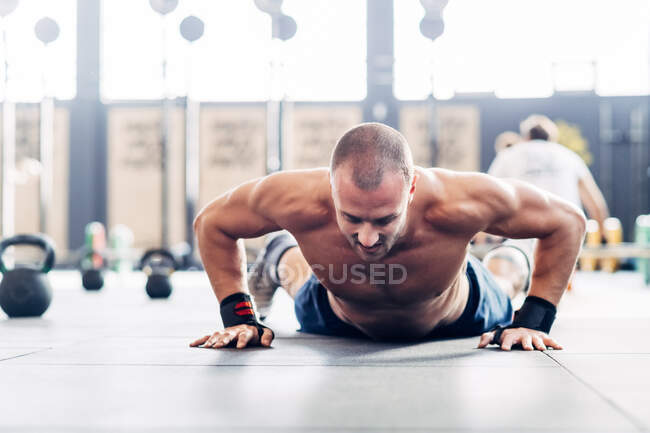 Homem fazendo flexões no ginásio — Fotografia de Stock