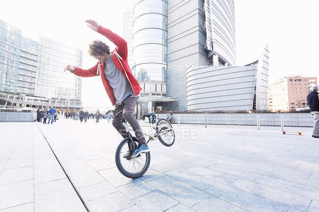 Masculino BMX motociclista fazendo acrobacias na área urbana — Fotografia de Stock