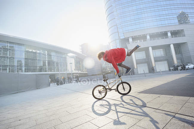 Masculino BMX motociclista fazendo acrobacias na área urbana — Fotografia de Stock