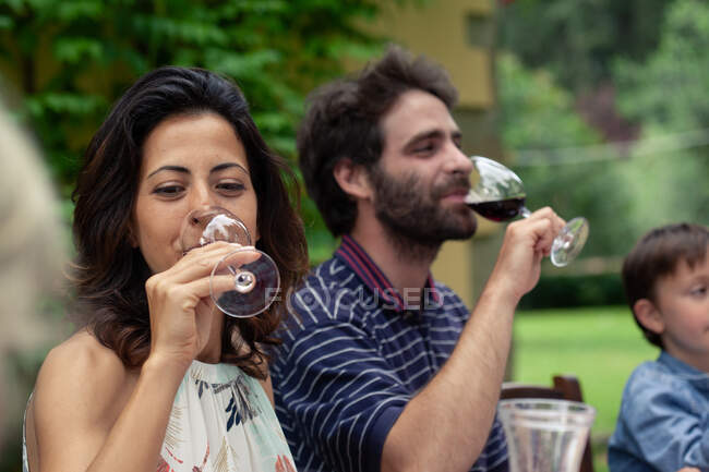 Пара насолоджується червоним вином під час сімейної їжі — стокове фото