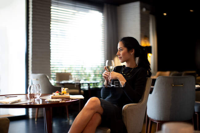 Mujer joven alojada en hotel boutique disfrutando de un aperitivo - foto de stock