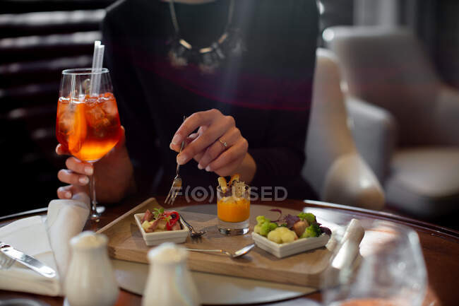 Cropped shot of young woman staying in boutique hotel eating aperitif — Stock Photo