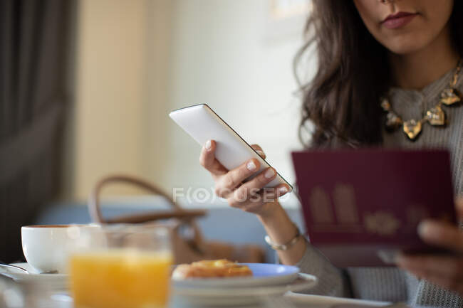 Foto cortada de jovem com tablet digital eletronicamente check-in enquanto toma café da manhã no hotel boutique na Itália — Fotografia de Stock