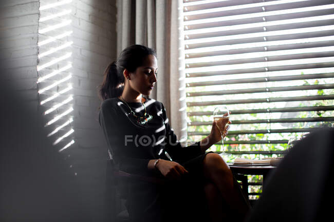Sophisticated young woman drinking champagne in boutique hotel restaurant, Italy — Stock Photo