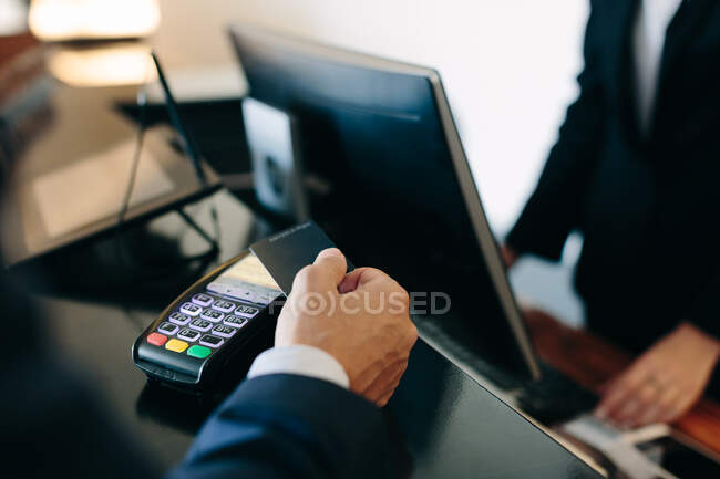 Homme d'affaires effectuant un paiement sans contact à la réception de l'hôtel — Photo de stock
