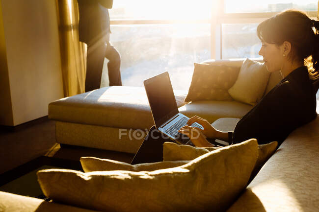 Empresario y mujer de negocios trabajando en el dormitorio del hotel - foto de stock