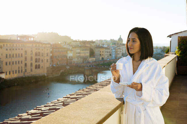 Femme prenant un café sur le balcon de l'hôtel, Florence, Toscane, Italie — Photo de stock