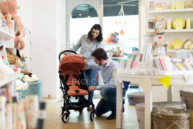 Marido e mulher grávida comprando carrinho de bebê — Fotografia de Stock