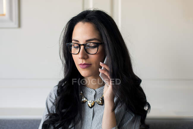 Молодая женщина разговаривает на смартфоне в бутик-отеле в Италии — стоковое фото