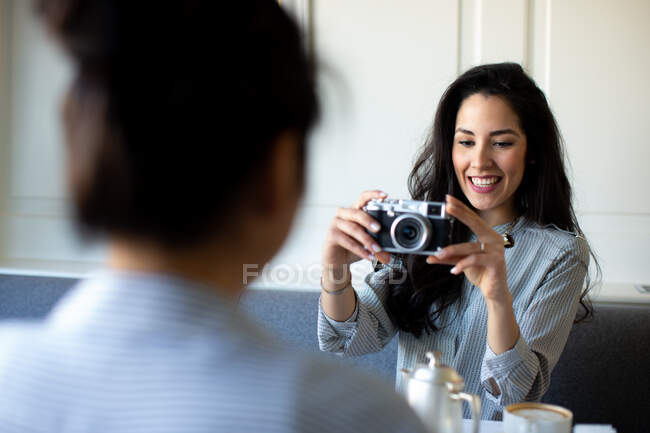 Giovane donna che fotografa un'amica mentre fa colazione in un boutique hotel in Italia — Foto stock