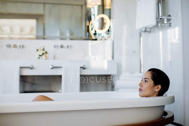 Woman relaxing in bathtub in suite — Stock Photo