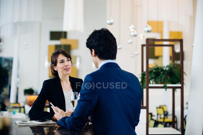 Businessman and businesswoman having drink at bar — Stock Photo