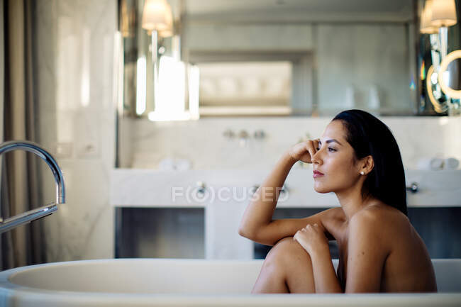 Mulher relaxante na banheira em suite — Fotografia de Stock
