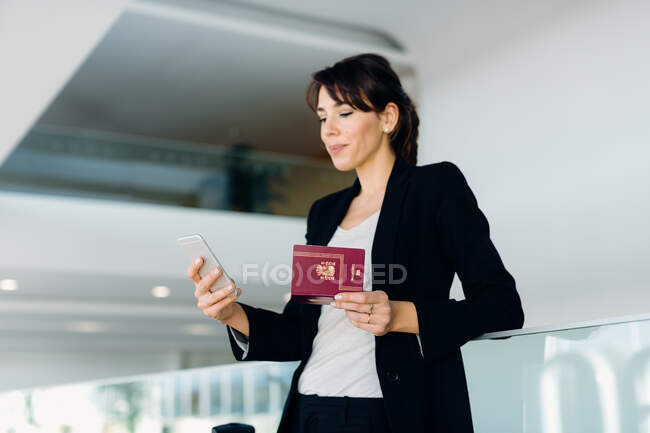 Mulher de negócios usando telefone celular para check-in eletrônico — Fotografia de Stock