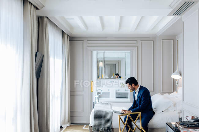 Businessman using laptop in suite — Stock Photo