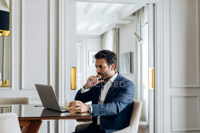 Homme d'affaires utilisant un ordinateur portable en suite — Photo de stock