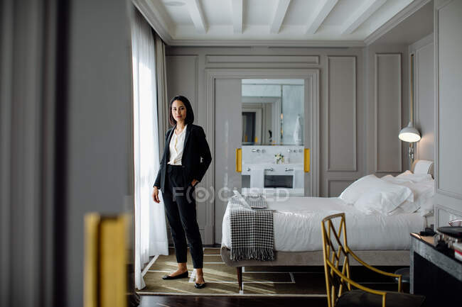 Geschäftsfrau neben Fenster in Suite — Stockfoto