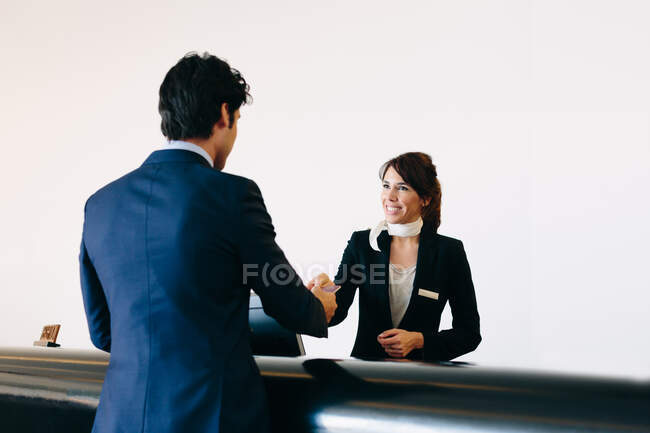 Businessman checking in at hotel reception — Stock Photo
